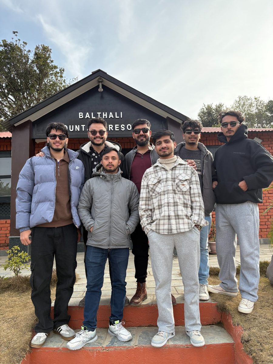 Seven colleagues standing together on the steps of Balthali Mountain Resort.