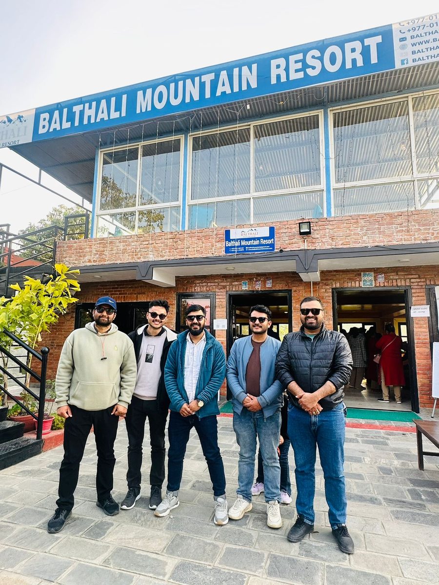 Five colleagues outside the entrance of Balthali Mountain Resort.